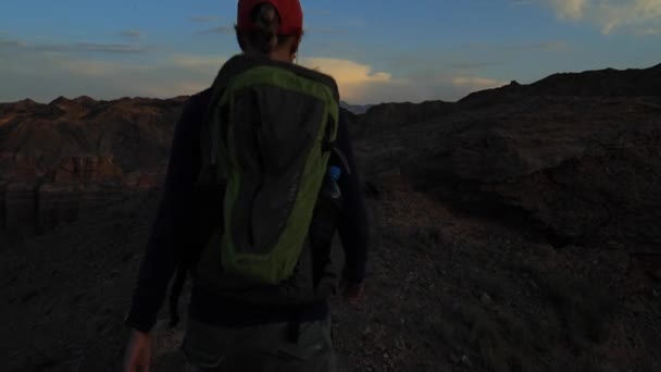 Jovem caminhando pelos Canyons ao pôr do sol — Vídeo de Stock