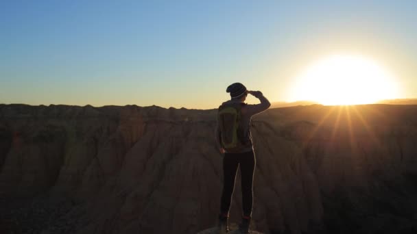 Giovane ragazza che cammina attraverso i canyon al tramonto — Video Stock