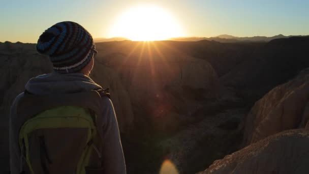 Giovane ragazza che cammina attraverso i canyon al tramonto — Video Stock