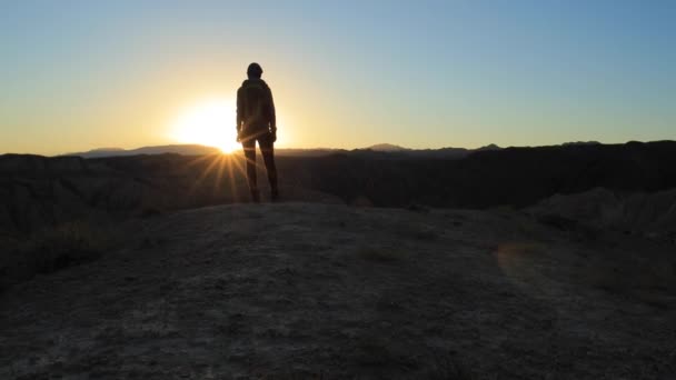 Giovane ragazza che cammina attraverso i canyon al tramonto — Video Stock