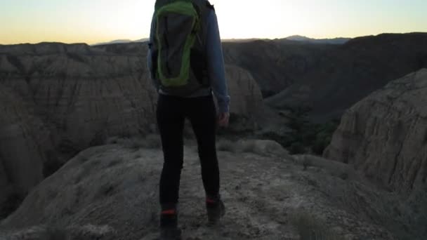 Молодая девушка, прогуливаясь по каньонам на закате — стоковое видео