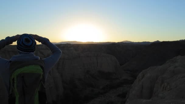 Jovem caminhando pelos Canyons ao pôr do sol — Vídeo de Stock