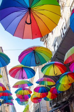 Lizbon 'da Gökkuşağı Açık Şemsiyeler Pembe Sokak' ta asılı. Şehir sanat kurulumu. Renkli desen. Yaz festivali sahnesi. Tavan dekorasyonu olarak şemsiyeleri aç.