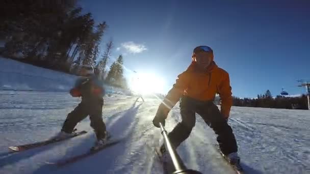 Niño se desliza en esquís alpinos con su padre — Vídeo de stock