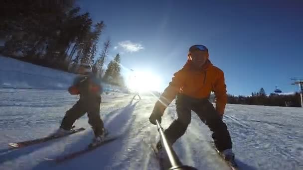 Liten pojke glider på alpina skidor med sin far — Stockvideo