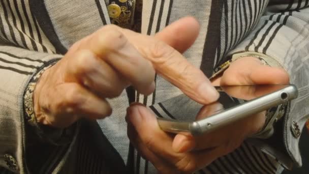 Hands of the old woman and smartphone. Close up Royalty Free Stock Video