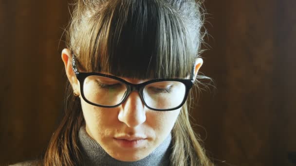 Mujer hermosa en grandes gafas negras lectura — Vídeo de stock