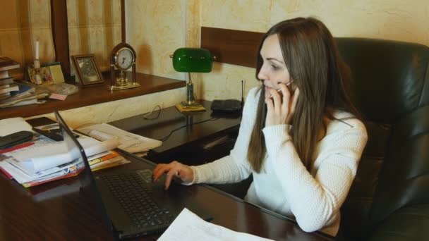 Donna d'affari che parla al telefono e legge il documento e lavora sul computer portatile nel suo ufficio — Video Stock