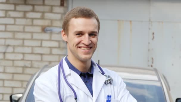 Πορτρέτο των νέων Καυκάσιος ιατρός χαμογελώντας εξωτερική — Αρχείο Βίντεο