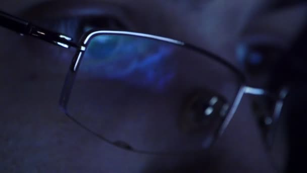 Close up shot of man in glasses surfing internet at night — Stock Video