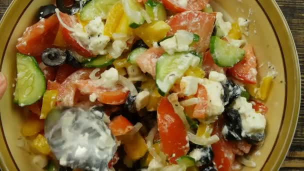 Stirring fresh vegetable salad with cheese feta in the kitchen . The mixing of vegetables. Close-up — Stock Video
