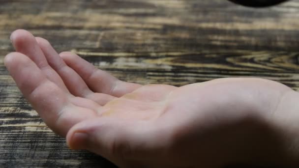 Großaufnahme eines Mannes, der ihr Tabletten in die Hand schüttet. medizinische Kapseln auf einer Handfläche — Stockvideo