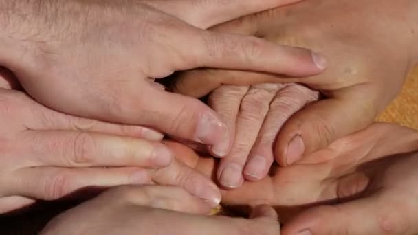 Muitas mãos confortando um velho par de mãos ao ar livre . — Vídeo de Stock