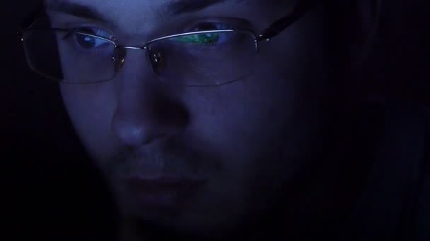 Nahaufnahme eines Mannes mit Brille, der nachts im Internet surft — Stockvideo