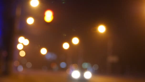 Car waiting green traffic light signal. Out of focus background with blurry unfocused city lights and driving cars and car light — Stock Video