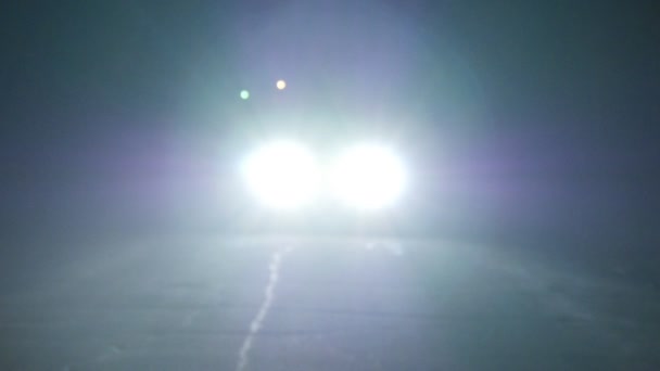 Moving car with lights at night. Car going on empty night road. In total darkness seen only the bright light of car headlights. — Stock Video