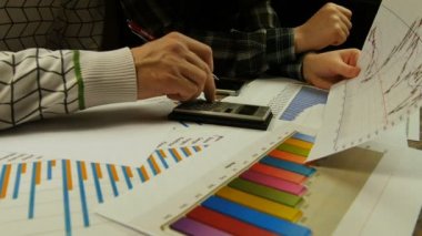 Grafik ve çalışma çizelgeleri yakın çekim tartışırken insanlar