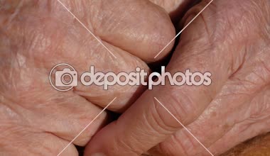Kadın kıdemli acı verici ellerini masajlar. Büyükanne yakın çekim parmakları kırışık cilt