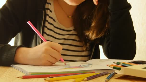 Mujer joven sostiene un lápiz y dibuja en casa. Colorear para adultos y niños. Para aliviar el estrés. Libro para colorear adulto — Vídeos de Stock