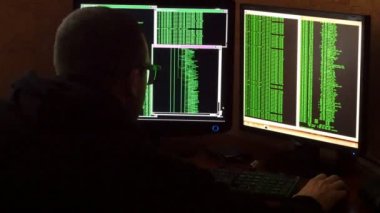 Hacker bardaklarda kod kırma. Ağ sistemi karanlık hacker odasından Penetran suç hacker. Ofiste iş yerinde bilgisayar programı yazar. Arkadan görünüş