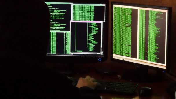 Hacker knacken Code. Krimineller Hacker mit schwarzer Kapuze dringt aus seinem dunklen Hackerraum in das Netzwerksystem ein.
