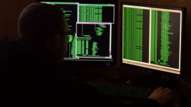 Hacker bardaklarda kod kırma. Ağ sistemi karanlık hacker odasından Penetran suç hacker. Ofiste iş yerinde bilgisayar programı yazar. Arkadan görünüş