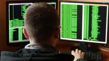 Hacker bardaklarda kod kırma. Ağ sistemi karanlık hacker odasından Penetran suç hacker. Ofiste iş yerinde bilgisayar programı yazar. Arkadan görünüş