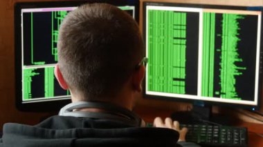 Hacker bardaklarda kod kırma. Ağ sistemi karanlık hacker odasından Penetran suç hacker. Ofiste iş yerinde bilgisayar programı yazar. Arkadan görünüş