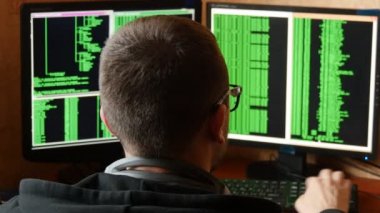 Hacker bardaklarda kod kırma. Ağ sistemi karanlık hacker odasından Penetran suç hacker. Ofiste iş yerinde bilgisayar programı yazar. Arkadan görünüş