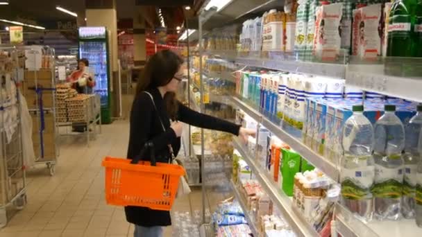 Jeune femme achetant des produits laitiers ou des produits réfrigérés au supermarché — Video