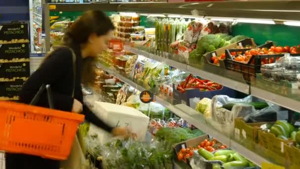 Atraktivní dívka vybrat rajčat v obchodě — Stock video