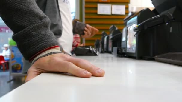 Klanten bestellen en betalen bij de balie in een café. Man neemt zijn geld en verbergt in zijn zak — Stockvideo