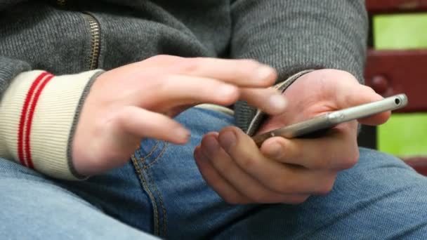 Primer plano de las manos masculinas usando teléfono inteligente al aire libre — Vídeo de stock