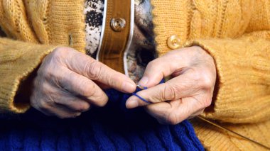 Yaşlı kadın evde oturur ve konfeksiyon dokuma kumaşlar