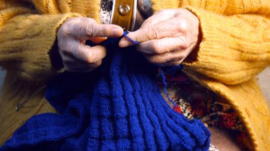 Grandmother knits a scarf clipart