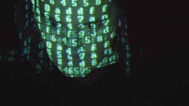 Nära upp skott av manliga ansikte hacker med binär kod projektioner. Källa koden beräknas över en arg fientligt mans ansikte, svart bakgrund. — Stockvideo