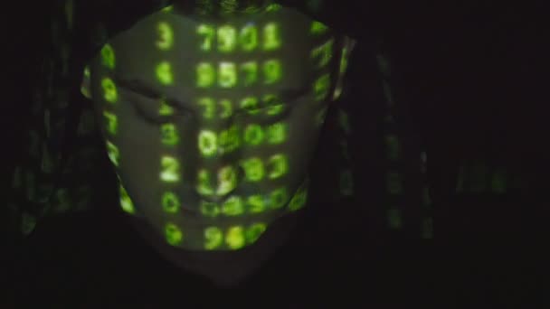 Close-up shot van mannelijke gezicht van hacker met binaire code projecties. Broncode over een boze vijandige geprojecteerd mans gezicht, zwarte achtergrond. — Stockvideo