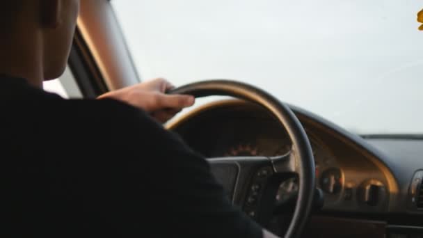 Jeune homme conduisant une voiture. Sérieux gars conduire voiture le long de la route de campagne, vue de l'intérieur de la voiture. Vue arrière arrière, plan steadicam, gros plan . — Video