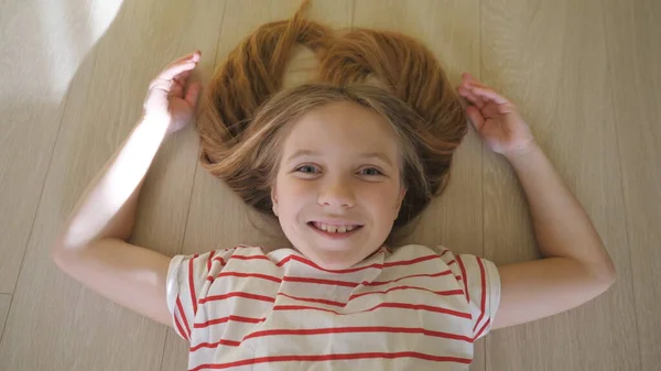 Mały Zabawny Dzieciak Leżący Podłodze Patrzący Kamerę Pokoju Szczęśliwa Uśmiechnięta — Zdjęcie stockowe