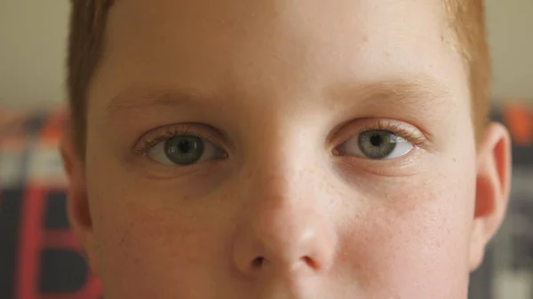 Закройте Голубые Глаза Маленького Рыжеволосого Мальчика Моргающего Смотрящего Камеру Усталым — стоковое фото
