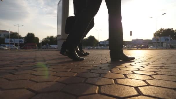 Feet of three businessmen walking in city with sun flare at background. Business men commute to work together. Confident guys being on his way to office. Colleagues going outdoor. Slow motion Close up — Stock Video