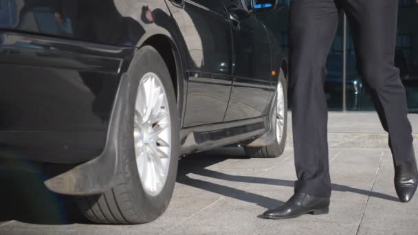 Hombre de negocios que viene al coche y abre la puerta para la hermosa mujer joven. Hombre destapa puerta de automóvil para pasajera. La chica sale del auto y se va con su novio. Moción lenta — Vídeos de Stock