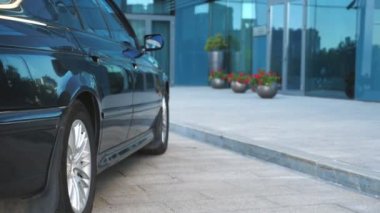 Otomobil modern binanın yanında duruyor. İş adamı arabadan çıkıyor ve ofise yürüyor. Tanımlanamayan bir iş adamı işe gidip geliyor. Takım elbiseli, kendine güvenen bir adam işe gidiyor. Yavaş çekim