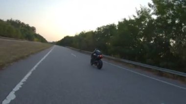 Motorcu, boş köy yolunda motorsikletle hızlanıyor. Sonbahar otobanında modern spor motosikletinde hızlı giden bir adam. Yolculuk sırasında bisiklet süren adam. Özgürlük ve macera kavramı. Hava görüntüsü