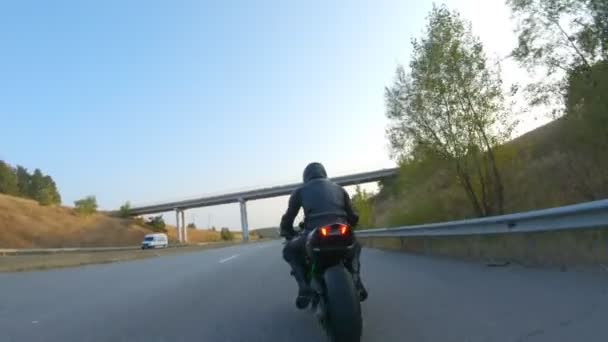 Siga para motociclista andando em moto esporte moderno na rodovia. Motociclista correndo sua motocicleta na estrada rural. Um tipo a conduzir bicicleta durante a viagem. Conceito de liberdade e aventura em viagem. Fechar — Vídeo de Stock