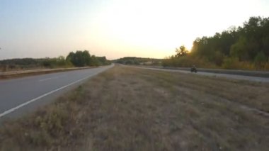 Sonbahar otobanında modern motosiklet kullanan motorcuya hava manzarası. Motosikletli güneşli bir günde kır yolunda motosikletiyle yarışıyor. Yolculuk sırasında bisiklet süren bir adam. Özgürlük ve macera kavramı