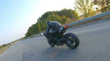 Otobanda motosiklet süren motosikletli bir motorcunun kamera görüntüsü. Motosikletli gün batımında kır yolunda motosikletiyle yarışıyor. Yolculuk sırasında bisiklete binen adam. Özgürlük ve macera kavramı.