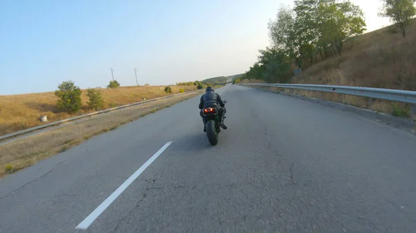 秋の高速道路で現代のスポーツバイクに乗って男の空中ショット オートバイ愛好家は田舎道でバイクレースをしている 旅行中にバイクを運転する男 自由と冒険の概念 上の図 — ストック写真