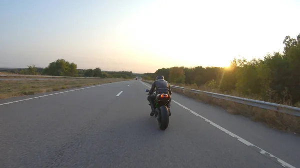 秋の高速道路で現代のスポーツバイクに乗って自転車に空中ビュー オートバイ愛好家は晴れた日に田舎道でオートバイを走らせている 旅行中に自転車を運転する男 自由と冒険の概念 — ストック写真