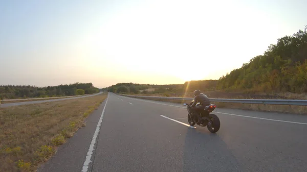 秋の高速道路で現代のスポーツバイクに乗って自転車に空中ビュー オートバイ愛好家は晴れた日に田舎道でオートバイを走らせている 旅行中に自転車を運転する男 自由と冒険の概念 — ストック写真